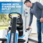 Man plugs HART riding mower into 120V outlet for charging