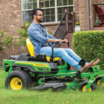 Man mowing lawn on a John Deere Z335E zero-turn mower
